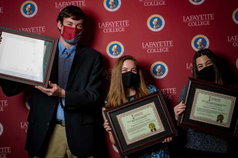 Student representatives of Engineers Without Borders holding Aaron O. Hoff Awards and standing in front of Lafayette College backdrop
