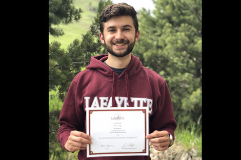 Evan Savage holds certificate