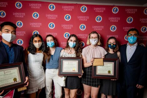 Student representatives of International Students Association holding Aaron O. Hoff Awards and standing in front of Lafayette College backdrop