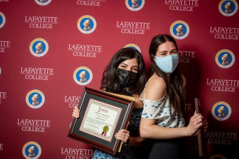 Student representatives of LafKid Connect holding Aaron O. Hoff Awards and standing in front of Lafayette College backdrop