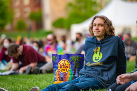 A student smiles while sitting on the Quad.