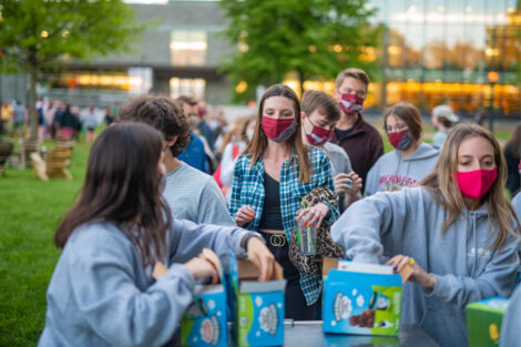 Students, wearing masks, grab a pint of ice cream.
