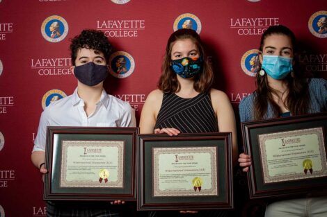 Student representatives of Winternational Orientation holding Aaron O. Hoff Awards and standing in front of Lafayette College backdrop