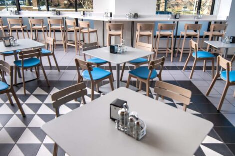 interior of Trolley Stop, tables, blue chairs, black and white floor