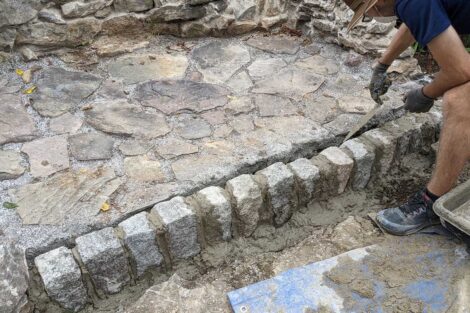 A rock wall at the front of the fire pit is set in mortar