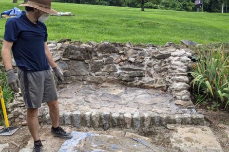 Student stands before the nearly final fire pit