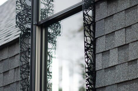 Laser cut shutters pattern the outside of a window