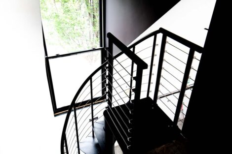 Spiral staircase in silhouette with bright window in background