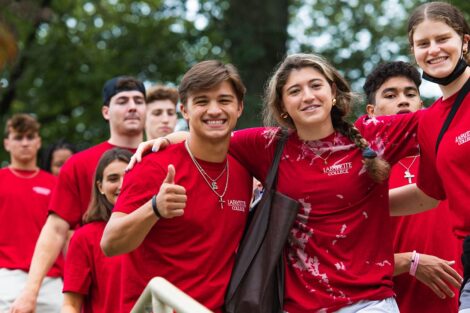 students in matching red Tshirts smile and give thumbs up