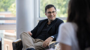Justin Hines smiles while sitting in a chair
