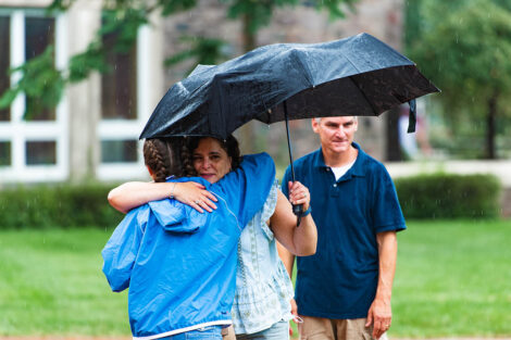 Lafayette student hugs mom holding umbrella goodbye