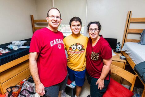 Lafayette student smiles with parents inside a dorm room