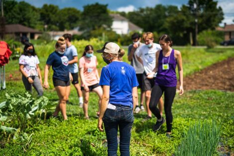 Lisa Miskelly stands with students on the fields of LaFarm.