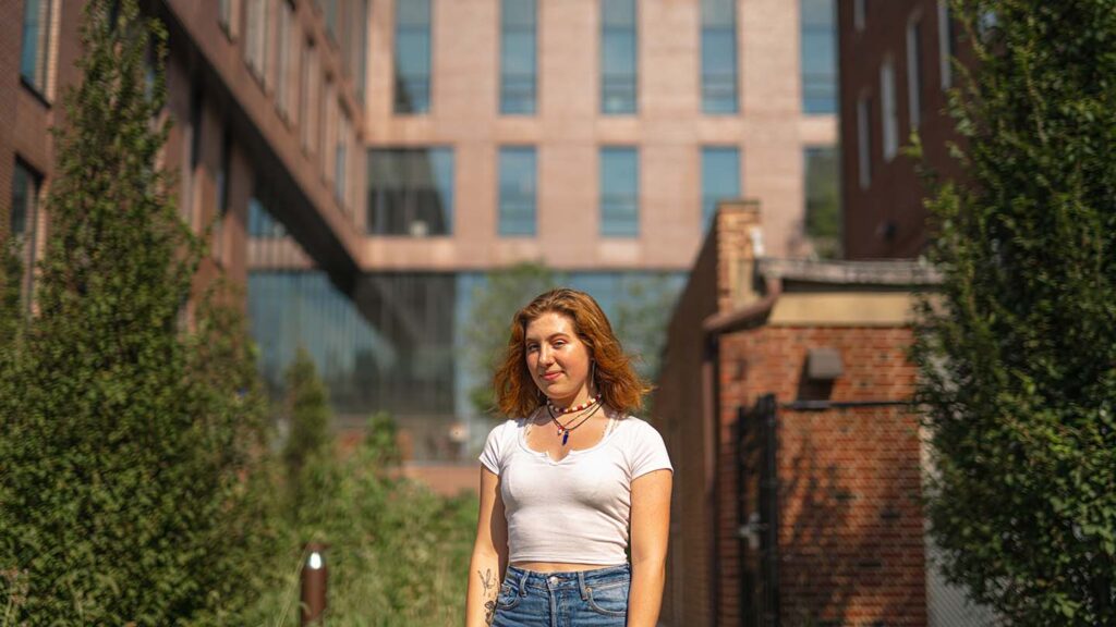 Abigail stands between the buildings at the lower courtyard in Rockwell