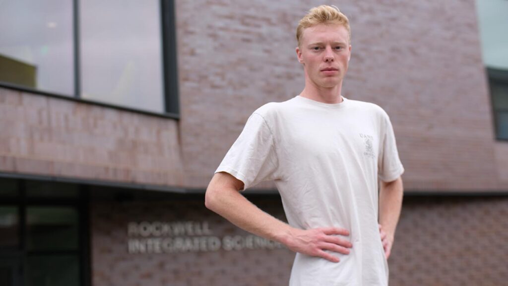 Carter has his hands on his hips at the entrance to Rockwell