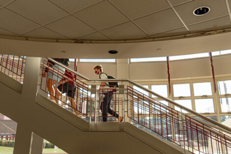 Families, masked, walk up stairs of Kirby Sports Center