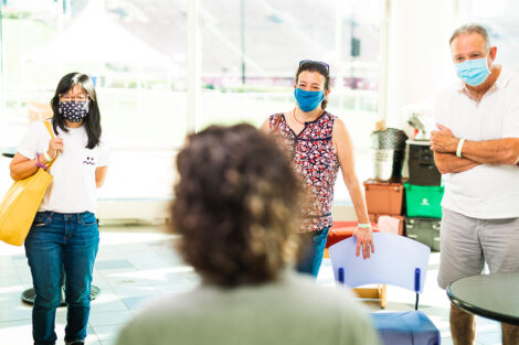 Families, wearing masks, stand in the lobby of Kirby Sports Center