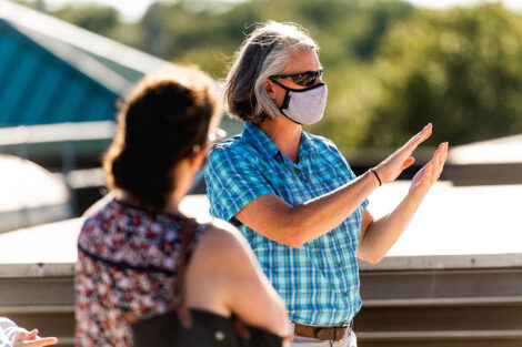 Professor Kira Lawrence, masked, leads a conversation on top of Kirby Sports Center