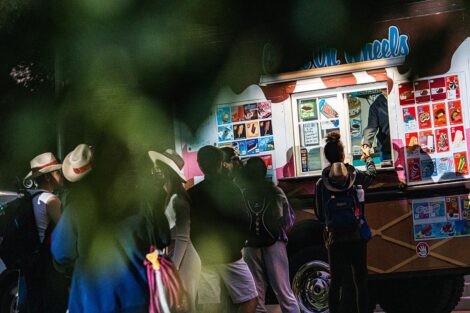 Students stand in line in front of an ice cream truck.
