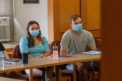 Students, wearing masks, sit in desks inside of a classroom at Lafayette College.