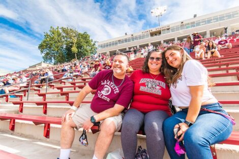 A family watches the football game from the stands of Fisher Stadium.