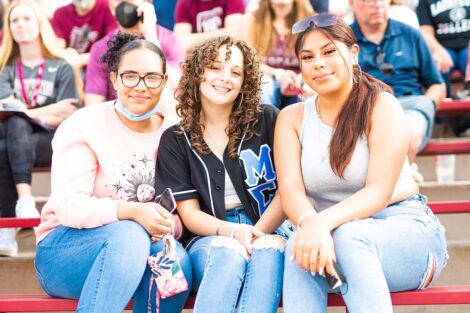 A family watches the football game from the stands of Fisher Stadium.