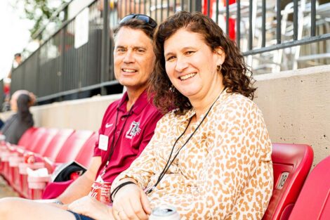 President Nicole Hurd and Bill Hurd sit in the stadium of Fisher Field.