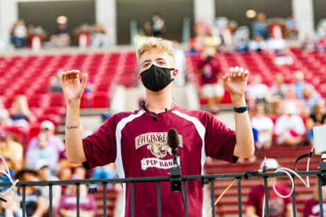 A student conducts the band on Fisher Field.