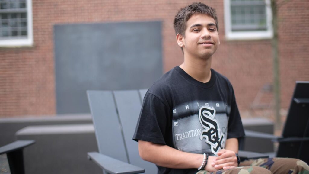 Jamil sits at the chalkboard class space outside Rockwell