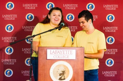 Students speak at a podium.