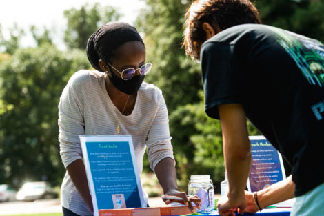 students gather at information table to learn about Thrive