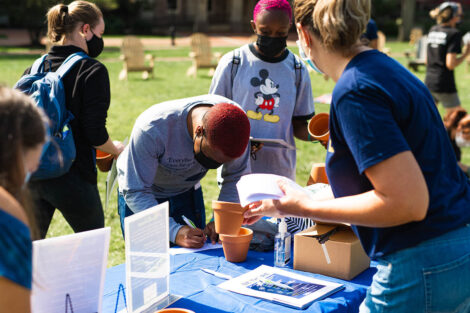 students gather at a table on the Quad to learn about Thrive