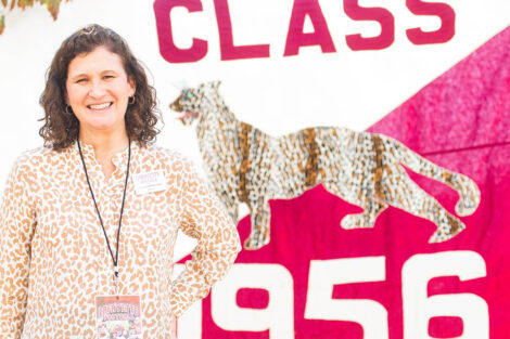 Nicole Hurd stands in front of a Class of 1956 flag.