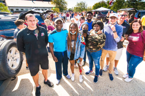 Families smile on Markle Parking Deck while tailgating.
