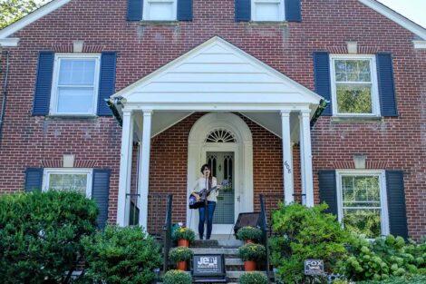 singer and guitarist performs on a porch