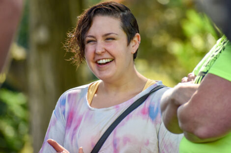 young person smiles in tie-dye shirt