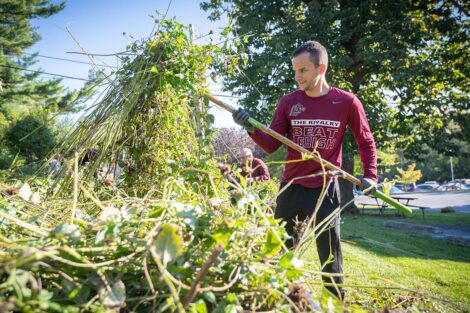 A staff volunteer pulls weeds.