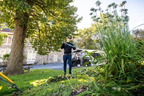 A staff volunteer tend to a garden.