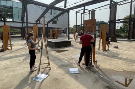 Students stand in center of plaza and draw at their easels