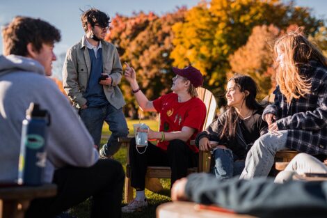 students sit in Adirondack chairs on the Quad