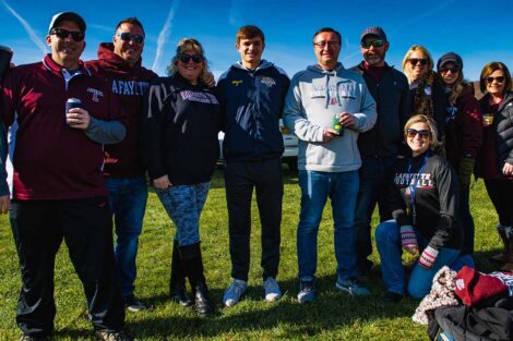 group of alumni in Lafayette gear smile outside