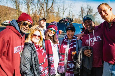 group of alumni in Lafayette gear smile outside
