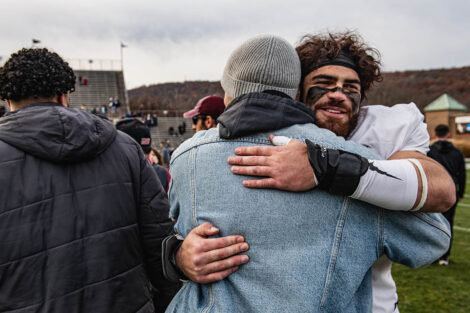 Lafayette football player hugs someone on the field