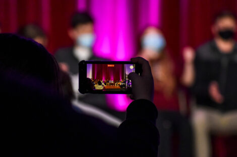 A student records hypnotist Erick Kand event on their phone.