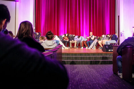 Students are slumped over in their chairs next to hypnotist Erick Kand.