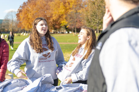 Two people talk to each other, wearing matching Rivalry long sleeved shirts.