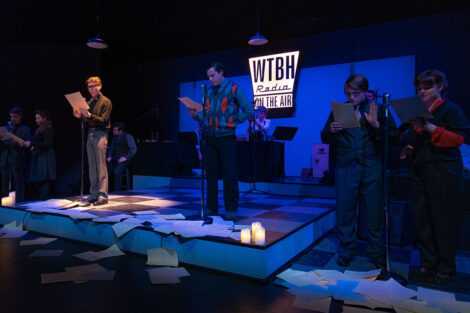 blue light illuminates actors on stage during production
