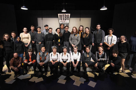 full cast of performance gather together on stage for group photograph