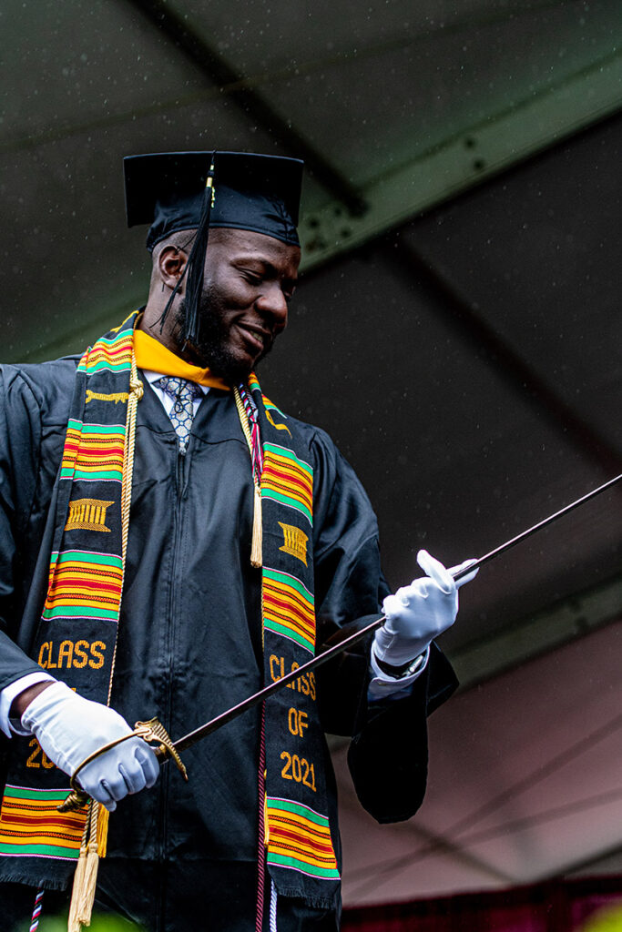 Basit Balogun ’21 looks down at the sword of the Marquis de Lafayette, as rain pours down around him.