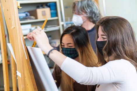 art students paint signs on easels
